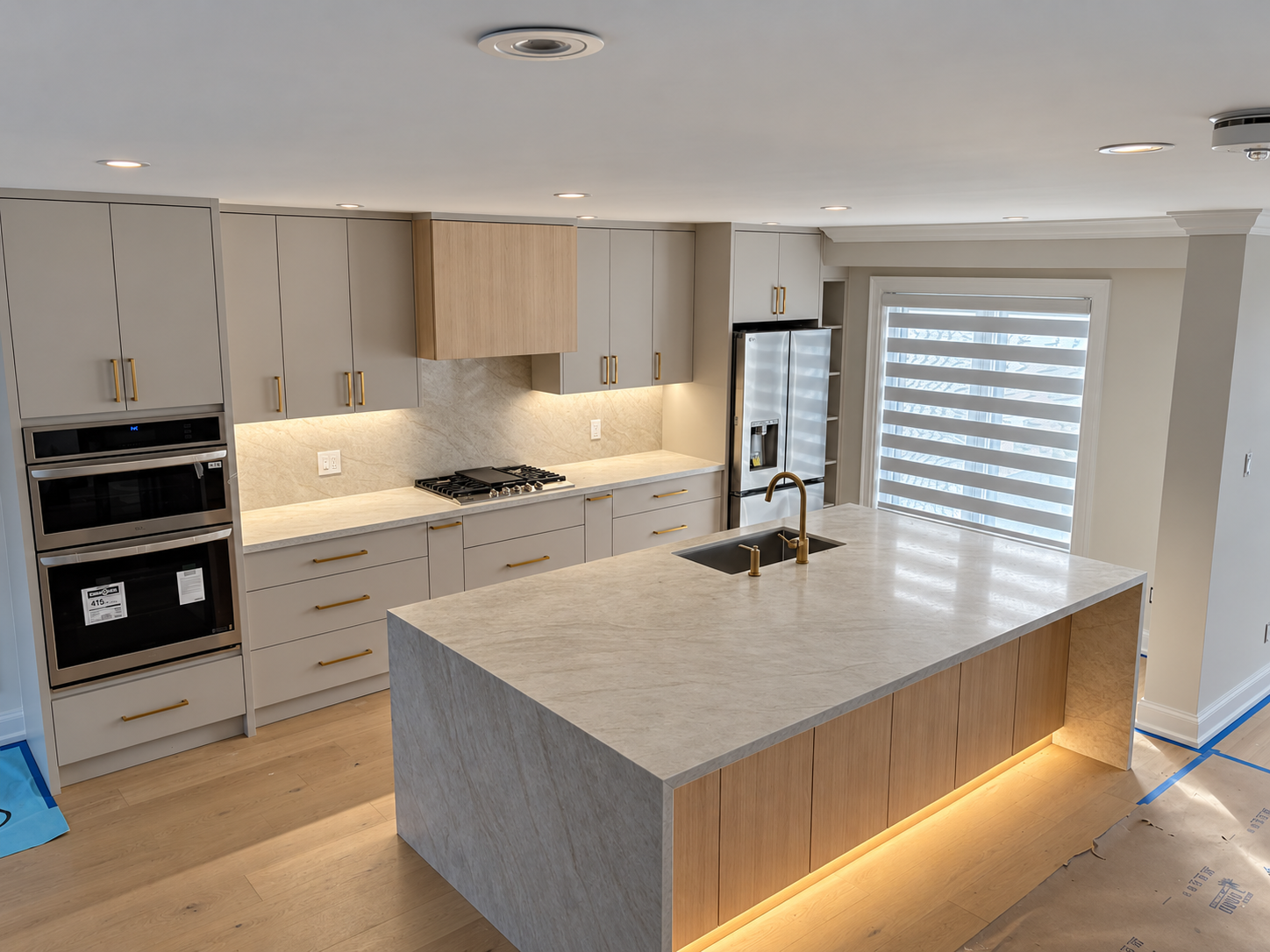 Angled view showing the completed kitchen island, cabinetry and integrated lighting