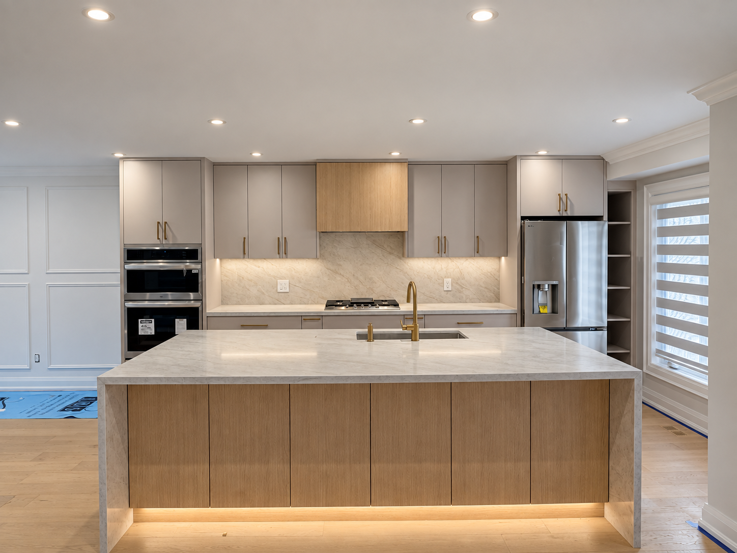 Recently completed ALCAN kitchen with custom cabinetry, an oversized stone island and integrated lighting